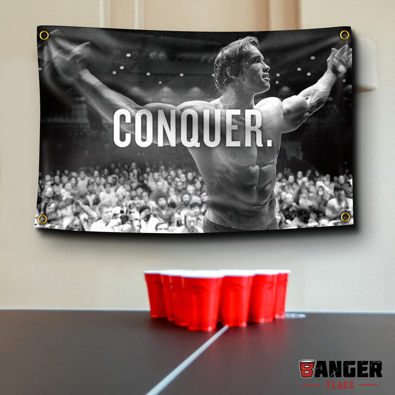 Banger Flags Banger - Original Arnold Schwarzenegger Conquer Motivational Inspirational Office Gym Dorm Wall Decor Design on a 3X5 Feet Flag with 4 Grommets for Easy Hanging. Authentic